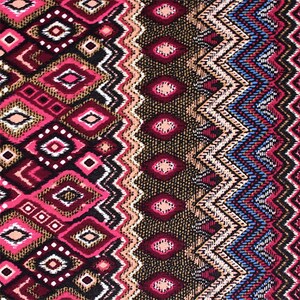 May include: A colorful fabric with a geometric pattern in shades of pink, brown, blue, and white. The pattern features a repeating diamond shape with a zig-zag border.