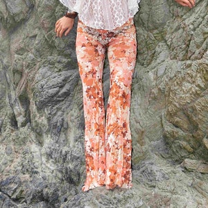 May include: A pair of wide-leg pants with a floral print in shades of orange, pink, and white. The pants are made of a lightweight fabric and have a relaxed fit.