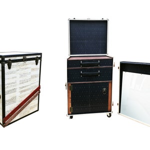 May include: Three vintage-style suitcases with black and white patterned exteriors. The suitcases have brass hardware and are arranged in a row. The suitcase on the left is closed, the middle suitcase is open with two drawers and a door, and the suitcase on the right is open with a mirror inside.