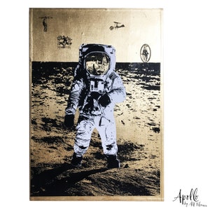 May include: A black and white image of an astronaut standing on the moon. The astronaut is wearing a white spacesuit with a black helmet. The background is a gold-colored surface with a black and white texture.