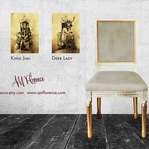 May include: Four framed illustrations of fantasy characters, including a queen, a king, a deer lady, and an astronaut, are displayed on a white wall. A white chair with gold legs sits in front of the wall. The chair is upholstered in a light beige fabric. The text "AM Florence" is written in cursive on the wall below the illustrations. The text "amflorence.etsy.com www.amflorence.com" is written below the cursive text.