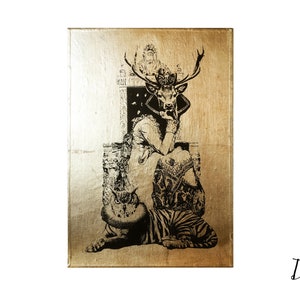 May include: A gold-toned canvas print featuring a black and white illustration of a deer-headed woman sitting on a throne with a tiger and an owl at her feet. The artwork is titled "Deer Lady" by AM Florence.