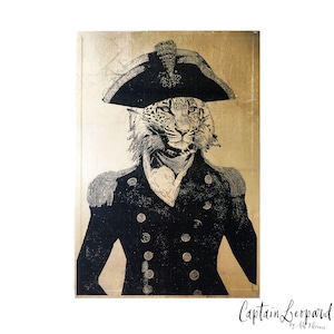 May include: A black and white illustration of a leopard wearing a gold-trimmed, black military uniform and a tricorn hat. The background is a gold metallic surface. The text "Captain Leopard by Alf Terence" is at the bottom of the image.