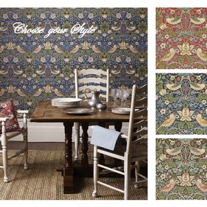 May include: A dining room with a wooden table and chairs, featuring a wallpaper with a floral and bird pattern. The wallpaper is available in three colorways: Crimson/Slate, Indigo/Mineral, and Chocolate/Slate. The text "Strawberry Thief" and the corresponding colorway are displayed next to each wallpaper sample.