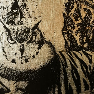 May include: A black and white image of an owl with a gold background. The owl's eyes are wide open and staring directly at the viewer. The owl is partially obscured by a black and white striped pattern.