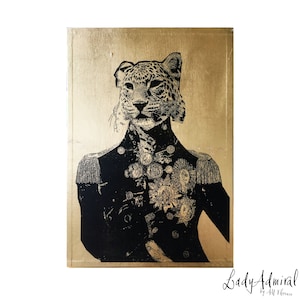 May include: A black and white illustration of a leopard wearing a military uniform with gold accents on a gold background. The image is titled "Lady Admiral" by Ali Florence.