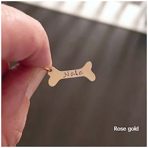 May include: Rose gold dog bone charm with the name "Nala" engraved on it.
