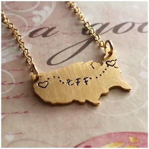 May include: Gold necklace with a map of the United States and the word "BFF" engraved on it. There are two small hearts on the necklace, one on each side of the word "BFF".