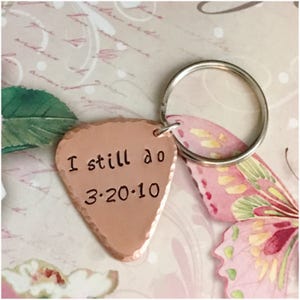 May include: Copper guitar pick keychain with the text "I still do 3-20-10" engraved on it.