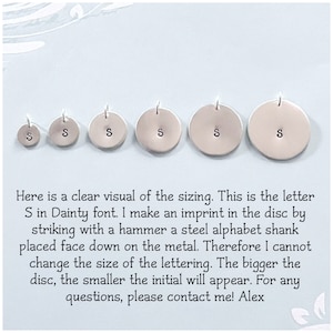 May include: Six silver discs with the letter "S" stamped in different sizes. The discs are arranged from smallest to largest. The text below the discs reads: "Here is a clear visual of the sizing. This is the letter S in Dainty font. I make an imprint in the disc by striking with a hammer a steel alphabet shank placed face down on the metal. Therefore I cannot change the size of the lettering. The bigger the disc, the smaller the initial will appear. For any questions, please contact me! Alex"