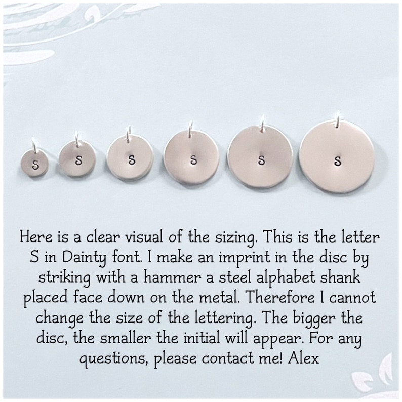 May include: Six silver discs with the letter "S" stamped in different sizes. The discs are arranged from smallest to largest. The text below the discs reads: "Here is a clear visual of the sizing. This is the letter S in Dainty font. I make an imprint in the disc by striking with a hammer a steel alphabet shank placed face down on the metal. Therefore I cannot change the size of the lettering. The bigger the disc, the smaller the initial will appear. For any questions, please contact me! Alex"