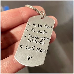 May include: Silver keychain with a heart and the text "Have fun, Be safe, Make good choices, Call Mom" engraved on it.