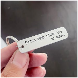 May include: Silver keychain with a message that reads "Drive safe, I love you Anna" with a heart symbol.