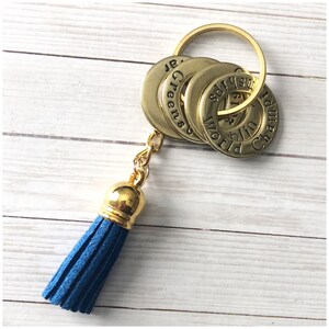 May include: Gold keychain with four round metal tags that say "World Champion", "Green Bay", "61", and "sdry" with a blue tassel.