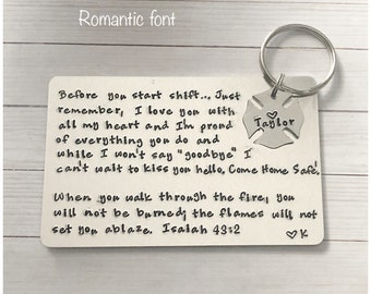 May include: A rectangular silver-toned metal wallet card engraved with black text reading Before you start shift... Just remember, I love you with all my heart and I'm proud of everything you do and while I won't say goodbye I can't wait to kiss you hello. Come Home Safe! When you walk through the fire, you will not be burned; the flames will not set you ablaze. Isaiah 43:2. A silver-toned metal keychain charm shaped like a Maltese cross is attached, featuring the name Taylor and a small heart symbol.