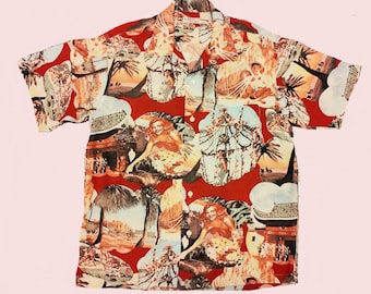 May include: A red short-sleeved button-up shirt with a colorful, tropical print featuring palm trees, women, and buildings. The print is a collage of different images.