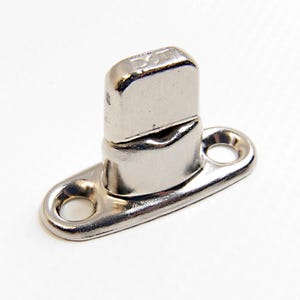 May include: A silver-toned metal snap fastener with a round base and a raised, rectangular top. The top has a small hole in the centre and the base has two holes on either side.
