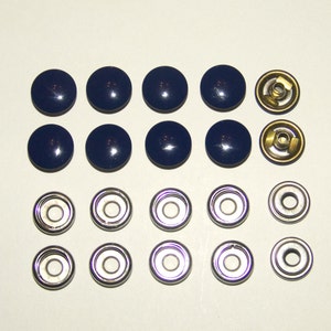 Puede incluir: Un surtido de broches de presión azul marino con un acabado brillante. El conjunto incluye las partes superior e inferior de los broches, con componentes metálicos de latón y plateados. Adecuado para ropa o proyectos de manualidades.
