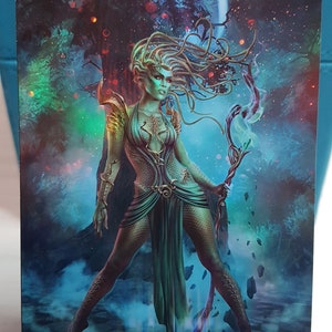 Könnte beinhalten: Ein Fantasy-Kunstdruck einer Frau mit grüner Haut und langen, fließenden Haaren, die ein grünes Kleid trägt und einen Stab hält. Der Hintergrund ist ein Wald mit blauem Himmel und Vollmond. Der Text "ORIGINAL CARD USED FOR THIS ALTER" befindet sich oben auf dem Druck.
