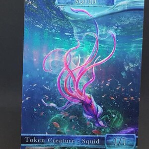 Peut inclure: Une carte de jeu de fantasy représentant un calmar rose et violet avec des tentacules, nageant dans un océan bleu et vert. Le texte de la carte indique "Token Creature - Squid 1/1 Islandwalk".