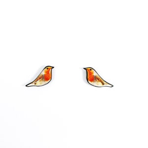 May include: A pair of small, red robin bird earrings. The birds are depicted in a realistic style with brown, white, and orange colors.