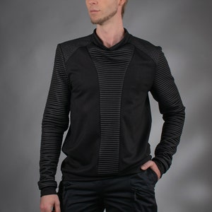 Man wearing black SP sweater with high collar and ribbed panels, front view – cyberpunk clothing