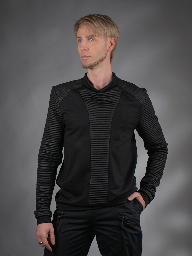 Man wearing black SP sweater with high collar and ribbed panels, front view – cyberpunk clothing