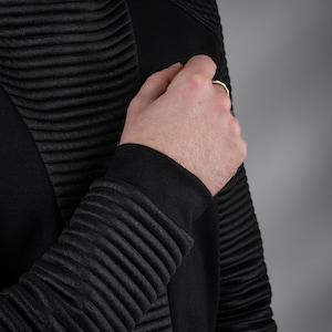 Man adjusting black SP sweater ribbed sleeve, close-up – techwear
