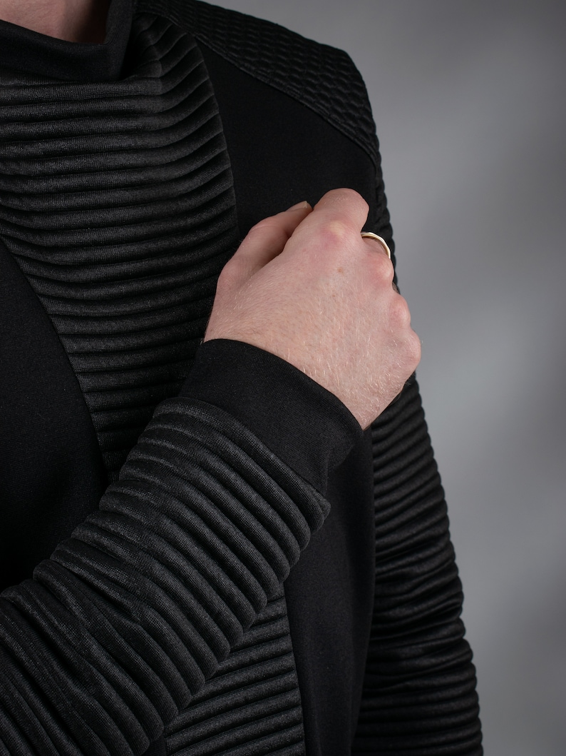Man adjusting black SP sweater ribbed sleeve, close-up – techwear