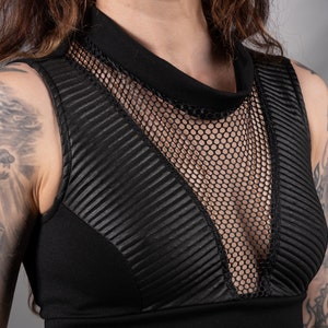 K&ouml;nnte beinhalten: Schwarzes &auml;rmelloses Crop-Top mit Mesh-Einsatz und Stehkragen.