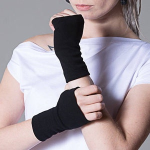 May include: A pair of black fingerless gloves. The gloves are made of a soft, stretchy fabric and are perfect for keeping your hands warm in the winter.