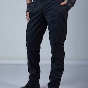 May include: Black tactical trousers with multiple pockets and a black belt. The trousers have a straight leg design and are made of a durable material. The trousers are paired with black leather shoes.