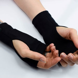 May include: A pair of black fingerless gloves with a thumb hole. The gloves are made of a soft, stretchy fabric and have a simple design.