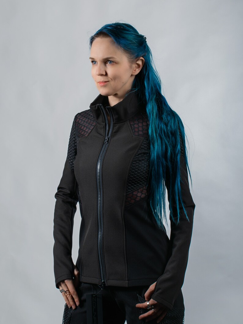 May include: A black zip-up jacket with mesh panels and a high collar. The jacket is worn by a person with blue hair.