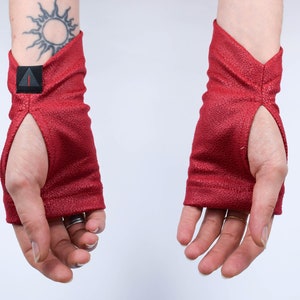 Red faux leather arm warmers with thumbholes, palms up, renaissance festival gloves