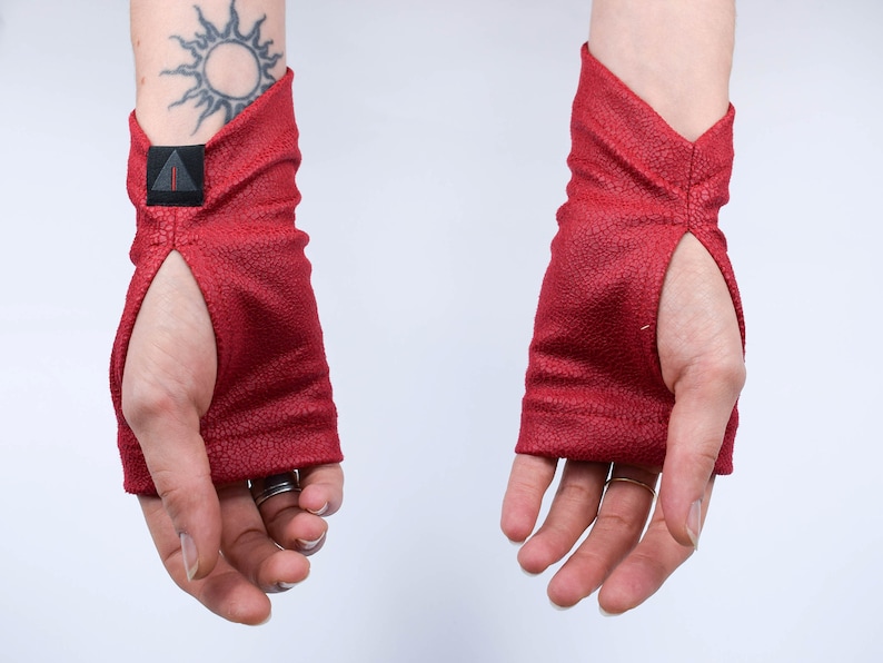 Red faux leather arm warmers with thumbholes, palms up, renaissance festival gloves