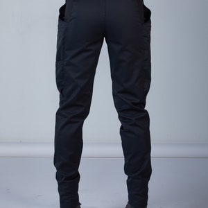 Puede incluir: Pantal&oacute;n cargo negro con cintur&oacute;n y dos bolsillos grandes a los lados.