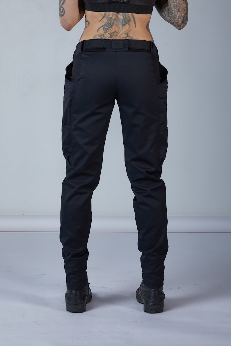 Puede incluir: Pantal&oacute;n cargo negro con cintur&oacute;n y dos bolsillos grandes a los lados.