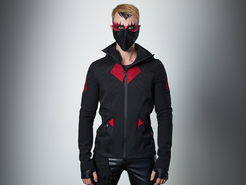 May include: A black hooded jacket featuring red mesh accents on the chest and shoulders, a full-length front zipper, and two zippered pockets. The jacket has long sleeves with thumb holes and is paired with black fingerless gloves and black pants.