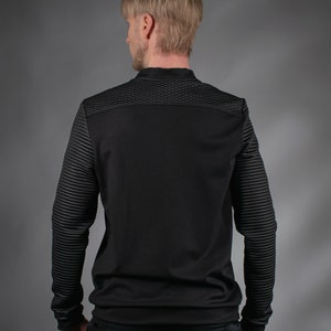 Man in black SP sweater with quilted shoulders, back view