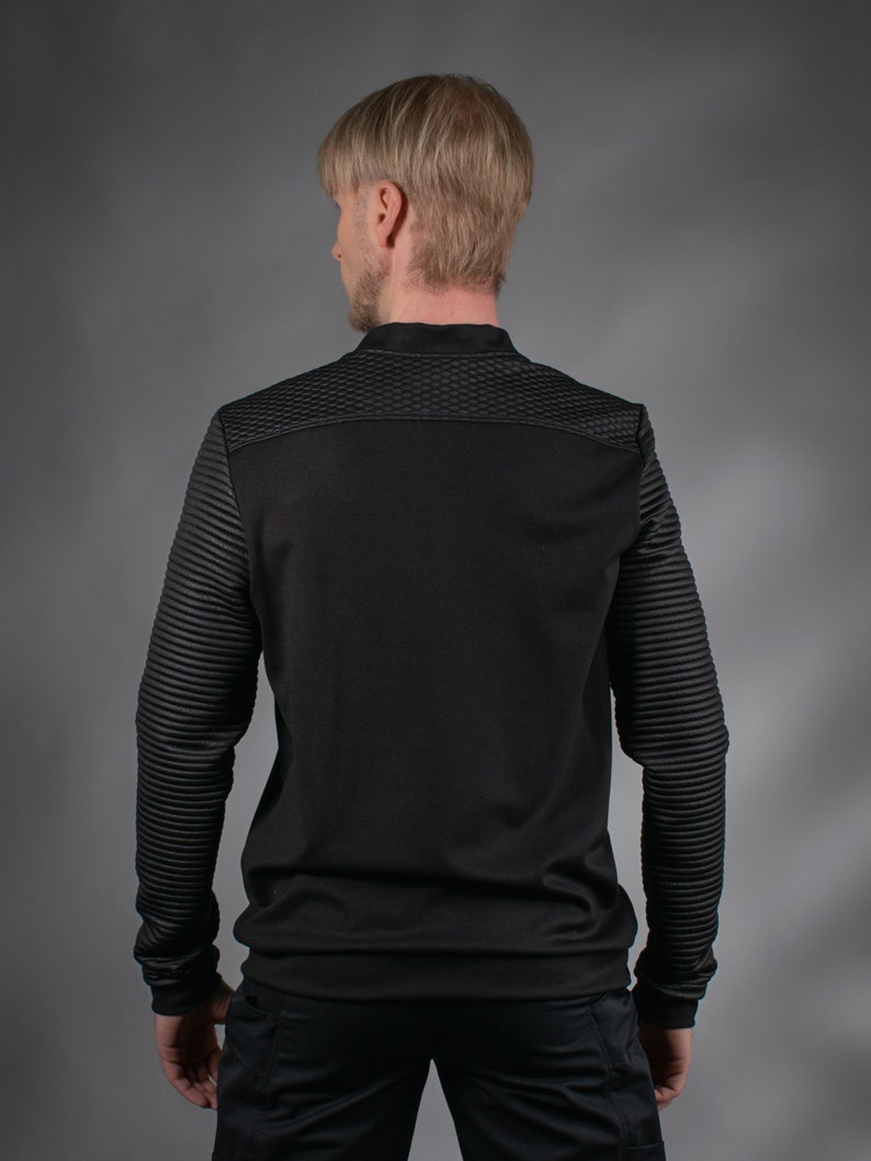 Man in black SP sweater with quilted shoulders, back view