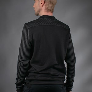 Man in black SP sweater, back view
