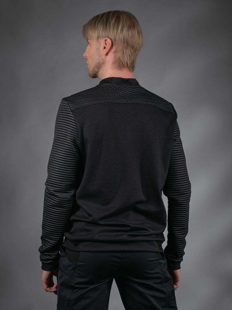 Man in black SP sweater, back view