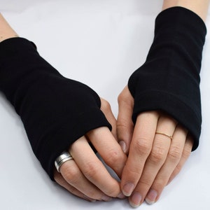 May include: A pair of black fingerless gloves made of a soft, stretchy fabric. The gloves extend to the wrist and have a simple, minimalist design.