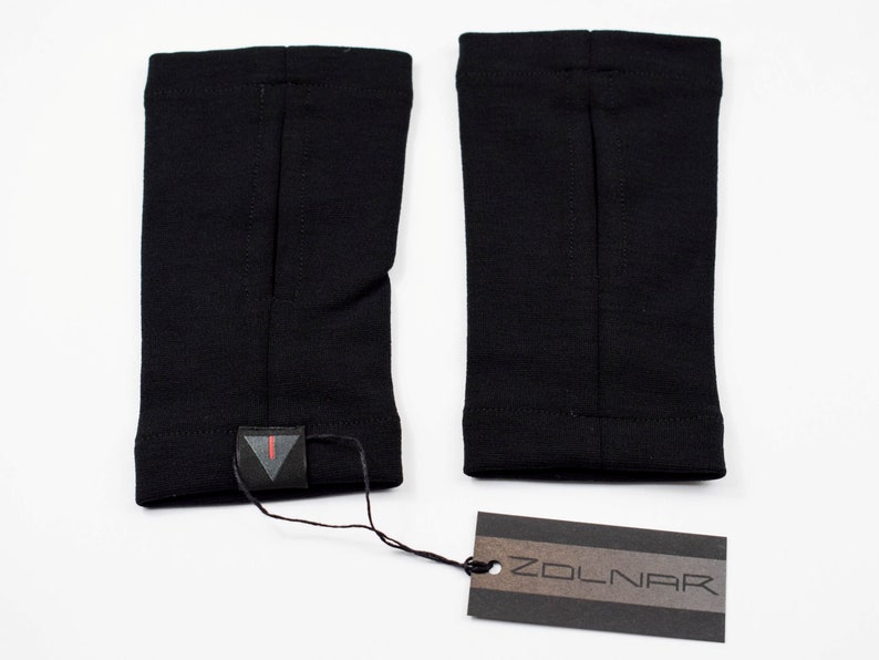 May include: A pair of black arm warmers with a small black triangle logo on one of the warmers. A black and brown tag with the word "ZOLNAR" is included.