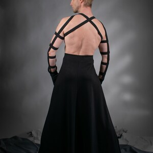 Man in black SK-L maxi skirt with crisscross harness, back view