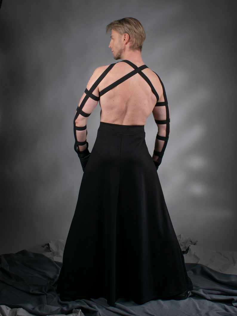 Man in black SK-L maxi skirt with crisscross harness, back view