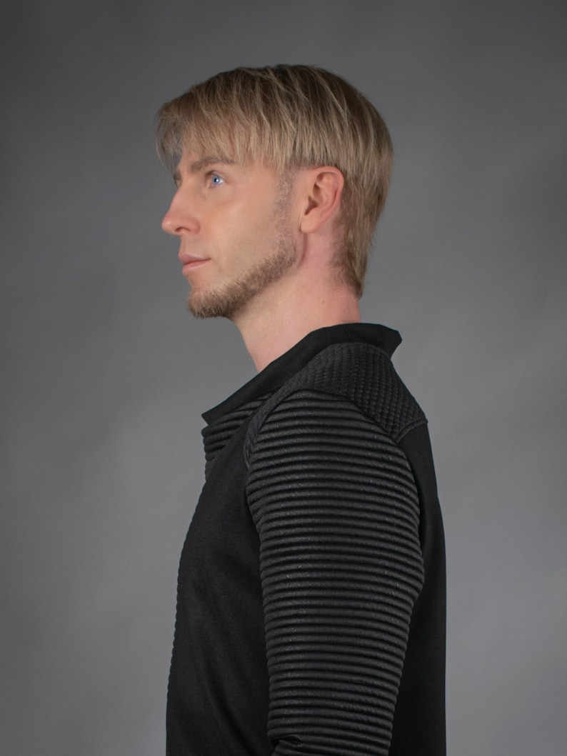 Man in black SP sweater, side profile