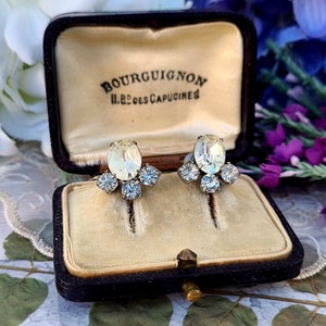 May include: A pair of vintage clear crystal earrings with a cluster of smaller crystals, in a black velvet jewelry box with the inscription "Bourguignon 11, Rue des Capucines".