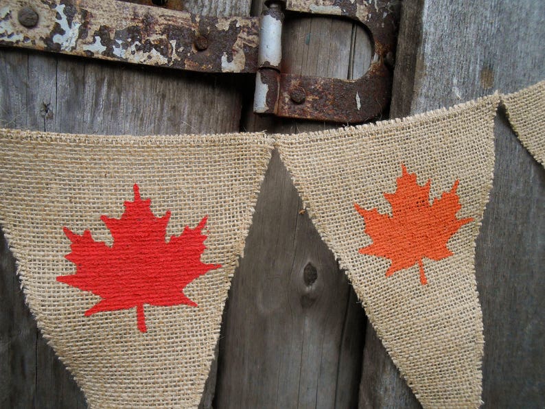 May include: A burlap banner with red and orange maple leaf designs. The banner is strung together with twine and is perfect for a Canadian themed party or celebration.
